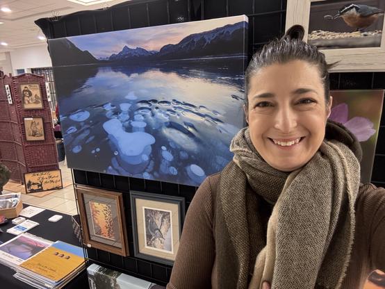 Selfie standing in front of my grid wall display of photo prints.