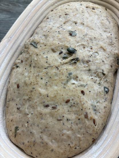Sourdough in a batard banneton displaying seeds, sage and seaweed.