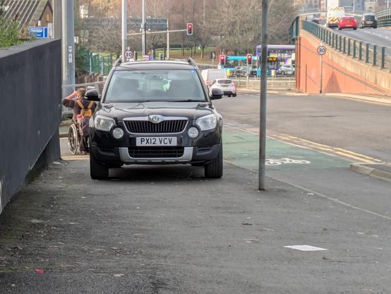 A Skoda car parked obstructing a pavement in Leeds. A man in a wheelchair can't get past it and had to come up the cycle lane.