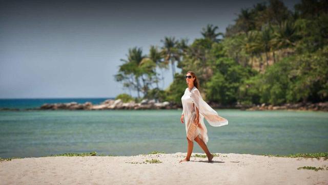 Woman on beach at Anantara Layan Phuket Resort. Photo courtesy Anantara Resorts.