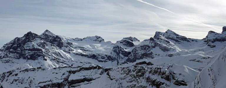 Bild zeigt ein winterliches Bergpanorama mit vielen Gipfeln und Graten, die mit Schnee bedeckt sind.