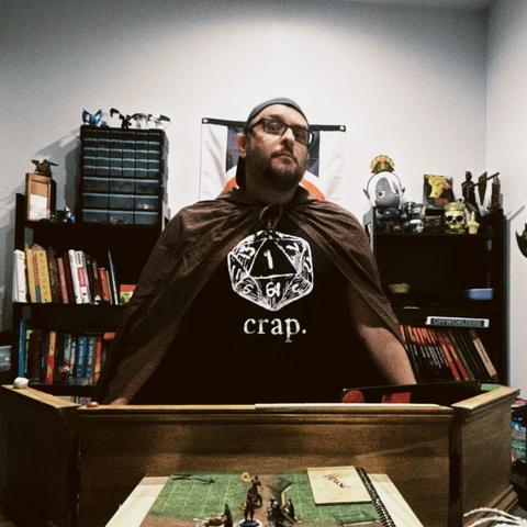 A photo of me wearing a cloak behind my GM screen running a game of Daggerheart.