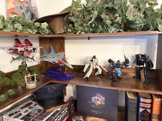 Shelf Transformers G1 JetFire reissue, MP-52 Starscream, crossover Maverick, crossover KITT/Agent Knight, and Lockdown. Hidden on the top shelf is an older NIB crossover Darth Vader/Tie Interceptor transformer.