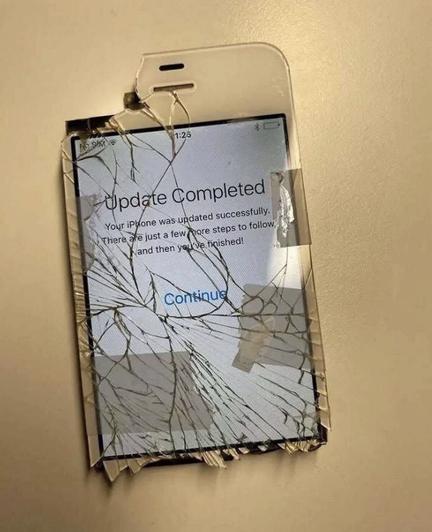 a severely mangled iphone 4 with text on screen saying "Update Completed"