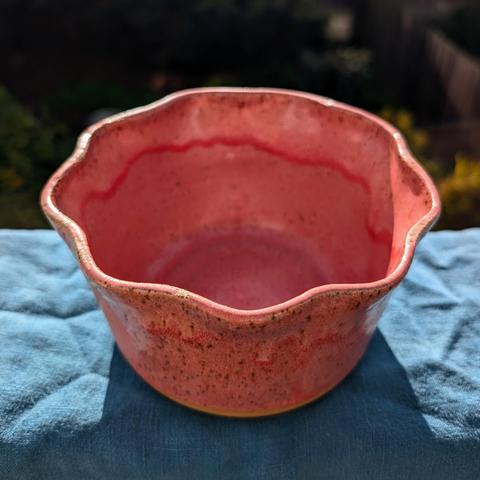 A pink cache pot with a ruffled edge, photographed on a teal cloth. CC BY-SA 4.0 Kate Zimmerman.