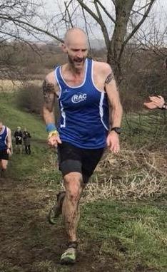 Bald, lanky guy wearing an RAC club vest and powering up a muddy hill at a cross country race. This was a two lap course, and literally half the course was shin deep in cheesy, stagnant water. I loved it!