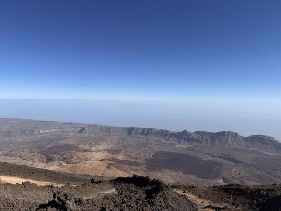 Widok na pustynną, skalistą krajobraz z dużym, szerokim horyzontem i bezchmurnym niebem.