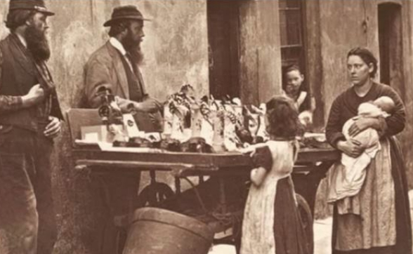 19th-century Street stall with men and a woman holding a baby.
TEXT: Dictionary Of Archaic And Probincial Words by Halliwell, James Orchard