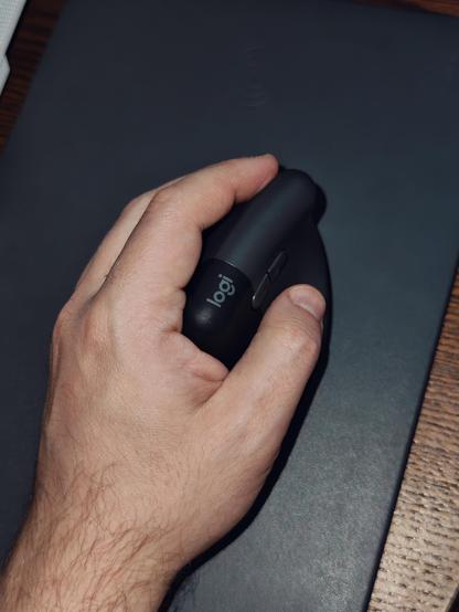 Left hand resting on a profiled, vertical mouse.