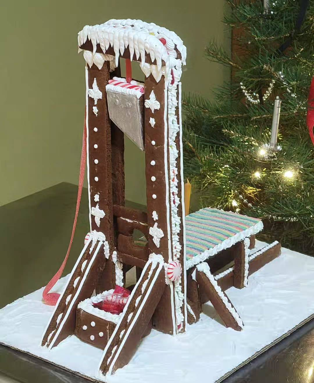 a guillotine made from gingerbread, decorated with white icing snow and icicles