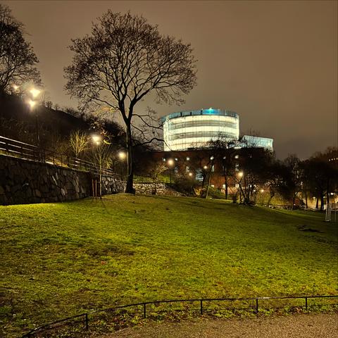 The Stockholm City Library is undergoing renovations, with its façade covered in a glowing tarpaulin. Architect: Gunnar Asplund.