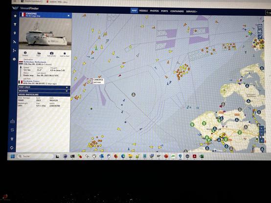 The image shows a maritime tracking interface displaying the vessel "CANPOEE." It includes details such as the ship's destination, current speed, and estimated time of arrival. The map features various colored markers representing other vessels and navigational elements in the surrounding