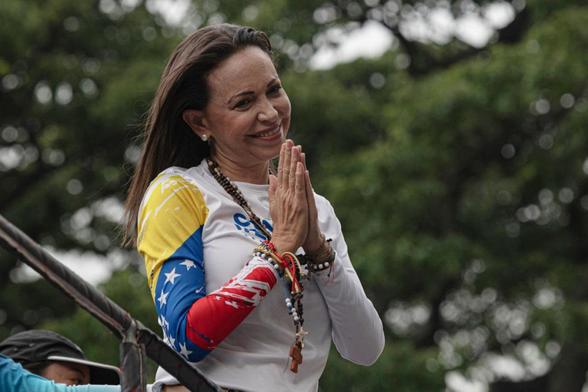 La líder opositora María Corina Machado saluda sus partidarios desde un camión durante el mitin de inicio de la campaña presidencial de Edmundo González Urrutia, el 4 de julio de 2024, en Caracas. (MARCELO PEREZ DEL CARPIO / Getty Images)