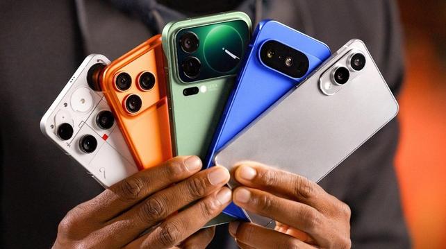 Marques Brownlee hält fächerartig fünf verschiedene aktuelle Smartphones in beiden Händen. Foto (c) MKBHD/YouTube.