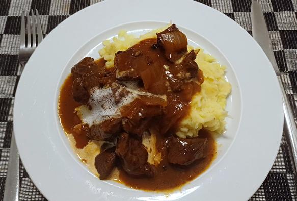 Gulasch mit Püree serviert