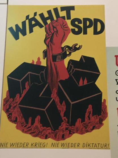 SPD-Plakat der 1950er Jahre: "Wählt SPD". Es zeigt eine rote, gesteckte Faust, die das Hakenkreuz durchbricht, zerbricht und seine Fessel sprengt.