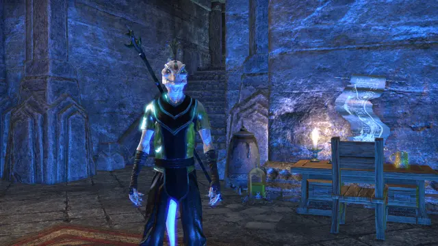 my guy standing by his desk in blue lighting, making his green shirt and eyes stand out