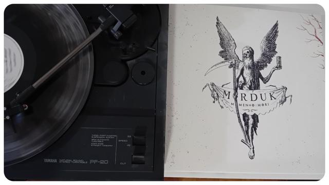 Pochette de l'album Memento : Mori du groupe Marduk.
Assez simpliste sur fond blanc avec une personne qui porte des ailes, une faux dans une main et on sablier dans l'autre.
Un morceau de tissus au niveau du pubis la recouvre avec le nom du groupe et de l'album dessus.