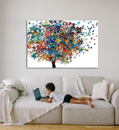 Colorful tree on crisp white by artist Sharon Cummings.  In a furniture setting with a little child on a sofa.