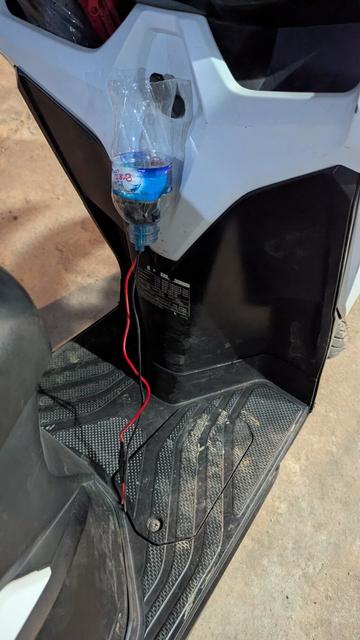 Mangels Kabellänge und Befestigungsmaterial wurde die Steckdose in eine aufgeschnittenen Wasserflasche integriert und diese am Roller eingehängt.