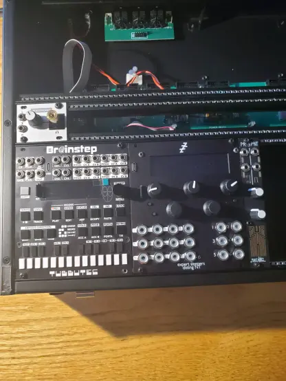 Close up of a mostly unfurnished modular synth. Modules include the Tubbutec Brainstep, Expert Sleepers Disting NT, Intellijel 1U headphone output, and Make Noise PrssPnt.