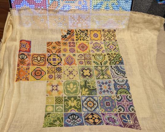 Unfinished multicolored cross stitch pattern.