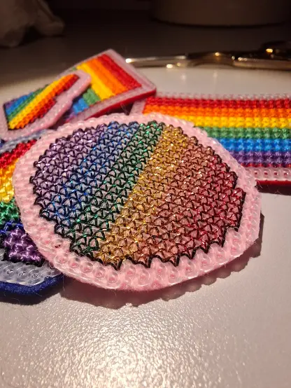 Zoom sur un rond aux couleurs rainbow brodés avec des fils effet métallique