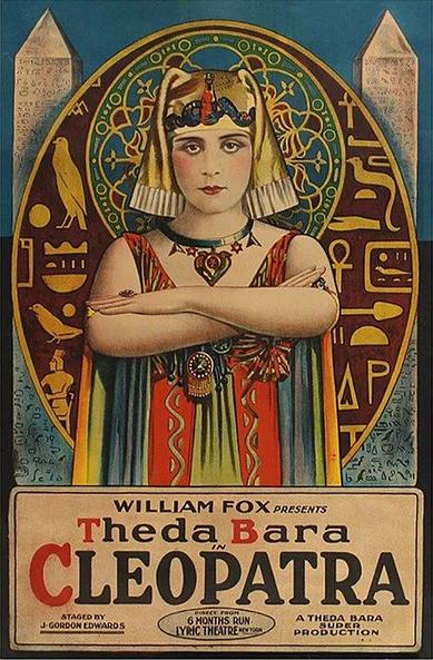 Original release poster. The poster is a striking piece of art, employing bold colors and stylized imagery to capture the essence of the film.
At the center of the poster, the actress Theda Bara is depicted as Cleopatra. She is positioned front and center, with her arms crossed over her chest. She is adorned in elaborate Egyptian-inspired attire, including a headdress, necklace with a heart-shaped pendant, and a richly decorated gown. Her expression is one of regal composure, with a slight hint of mystery.
Behind Cleopatra, a large circular design frames her. This design features Egyptian hieroglyphs, stylized birds, and ornate patterns in shades of green, gold, and red, evoking the artistic style of the era. On either side of the central figure are two tall, white obelisk-like structures, further reinforcing the Egyptian theme.