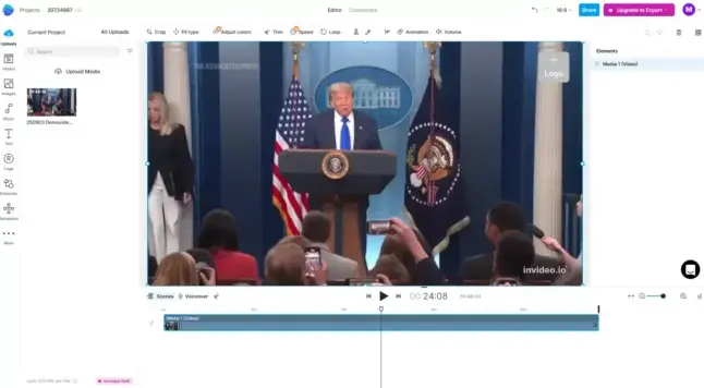 Ein Mann am Rednerpult mit US-Flaggen im Hintergrund, umgeben von Journalisten. Links steht eine Frau. Publikum hält Mobiltelefone hoch.