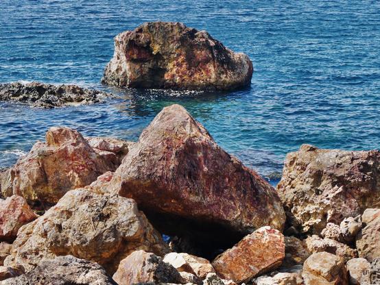 Photo de roche rougeâtre dans la mer bleu 

Photo of reddish rock in the blue sea