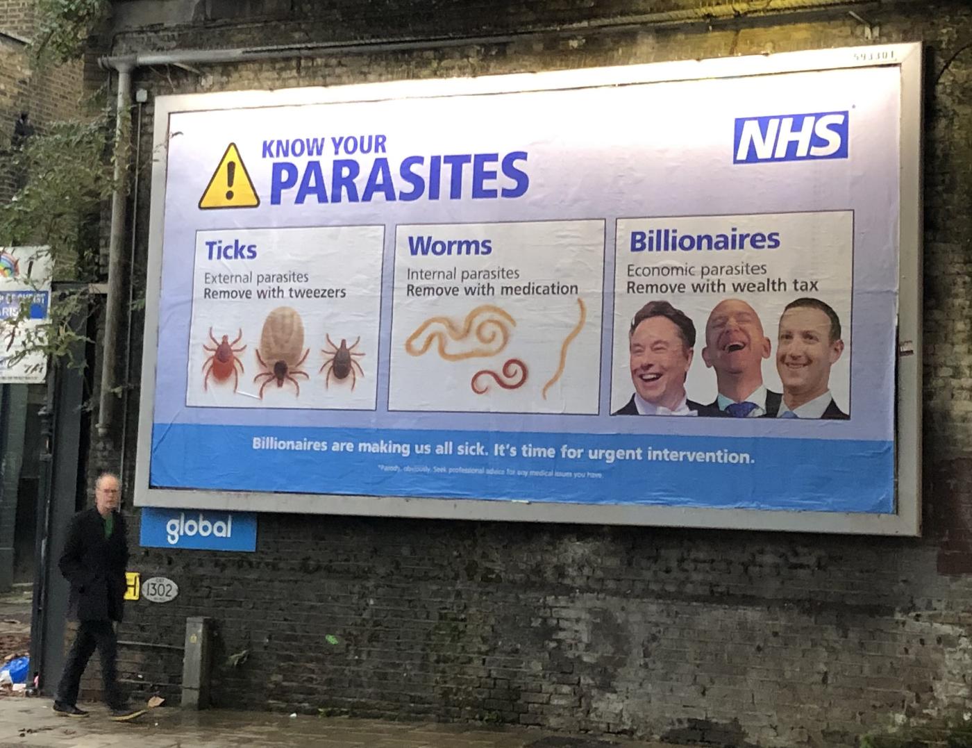A billboard, purportedly from the NHS, saying: KNOW YOUR PARASITES: ❝TICKS: External parasites. Remove with tweezers. [photo of ticks] WORMS: Internal parasites. Remove with medication. [photo of worms] BILLIONAIRES: Economic parasites. Remove with wealth tax. [photo of laughing Musk, Bezos and Zuckerberg]❞