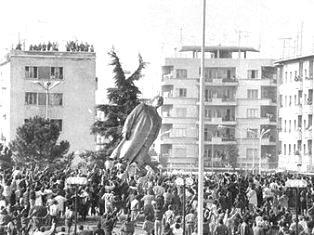 The toppling of Enver Hoxha's statue in Skanderbeg Square, central Tirana By "New Albania" magazine, Fair use, https://en.wikipedia.org/w/index.php?curid=30519881