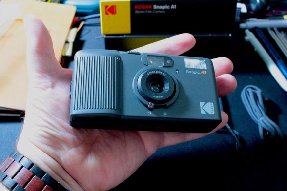 A photo of the Snapic A1 in my hand, showing the size of it.  The camera is surprisingly small for something with auto film advance / rewind.  Likely due to it's manual zone focus.  (it has two zones, close up and far,) .