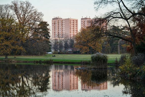 Teich in dem sich Wohntürme spiegeln