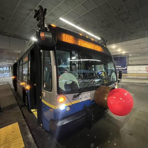 A transit bus, with eyes, a red nose, and antlers