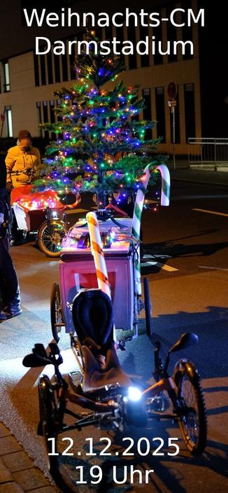Liegerad mit Anhaenger, auf dem ein beleuchteter Christbaum befestigt ist. Zwei Zuckerstangen sind auch am Anhaenger und am Liegerad befestigt.