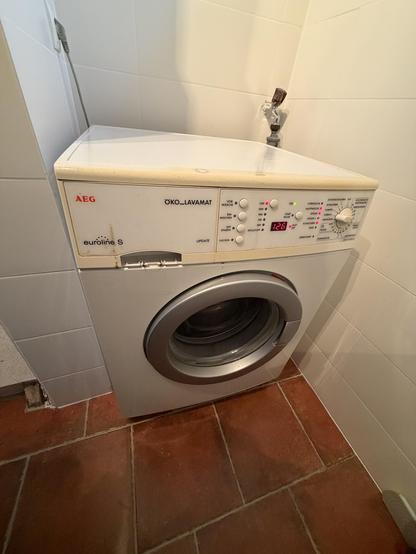 Foto einer AEG euroline S Waschmaschine. Die Plastikblende oben ist etwas vergilbt. Die Zeitanzeige leuchtet.