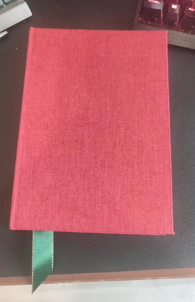 The planner view from the front cover, all red, with the green bookmark visible from the bottom left