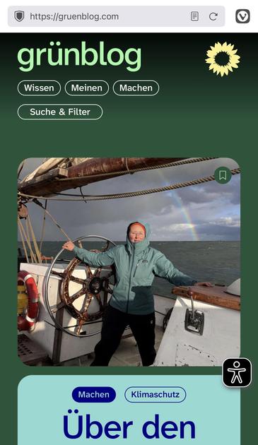Das Bild zeigt einen Screenshot der Website „grünblog“ (gruenblog.com). Im oberen Bereich der Website ist das Logo „grünblog“ in grünen Lettern zu sehen, begleitet von einer kleinen gelben Sonnenblume.

Darunter befindet sich die Navigationsleiste mit den Optionen: „Wissen“, „Meinen“, „Machen“ und „Suche & Filter“.

Im Hauptbild steht eine Person an Bord eines Segelschiffs. Die Person trägt eine hellblaue, winddichte Jacke mit Kapuze und steht lächelnd mit einer Hand am großen hölzernen Schiffsrad. Im Hintergrund ist das Meer zu sehen, über dem sich ein Regenbogen spannt. Der Himmel ist bewölkt, aber der Regenbogen bringt Farbe ins Bild.

Am unteren Rand des Bildes sind zwei weitere Kategorien zu sehen: „Machen“ und „Klimaschutz“. Der Text „Über den“ ist teilweise sichtbar, was auf einen Artikel oder eine Rubrik hinweist.