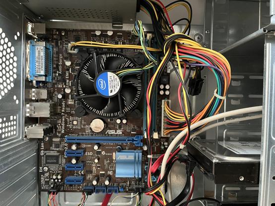 Inside of the computer with motherboard and large cooling fan.