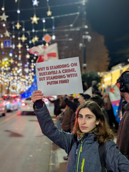 In Tbilisi, Georgia, protester holds sign with text:
"Why is standing on Rustaveli a crime, but stading with putin is fine?"