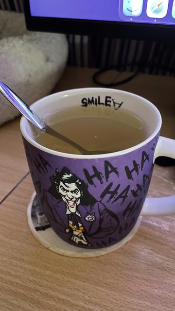 The freshly brewed tea in my purple Joker mug