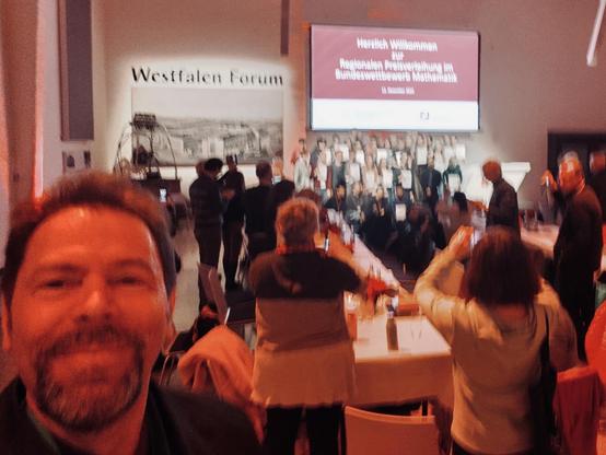 Ein Blick auf die Preisträger*innen der zweiten Runde im Bundeswettbewerb Mathematik aus Niedersachsen, Hamburg, Bremen, Schleswig-Hollstein und NRW im Westfalen Forum in Münster. Links schaue ich selbst in die Kamera.