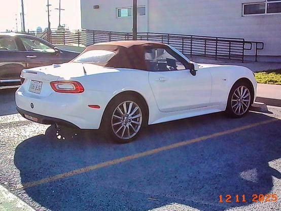A white 2018 Fiat 124 Spider with a red top.