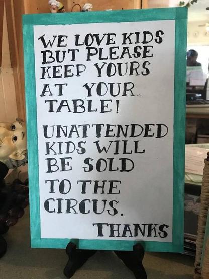 Schild mit der Aufschrift “WE LOVE KIDS BUT PLEASE KEEP YOURS AT YOUR TABLE!
UNATTENDED KIDS WILL BE SOLD TO THE CIRCUS. THANKS”