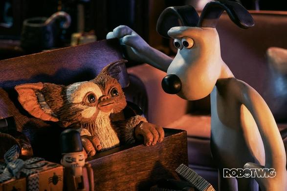 Gromit opens an old wooden case revealing Gizmo. Christmas presents surround them and the scene is lit with a warm glow from the fireplace