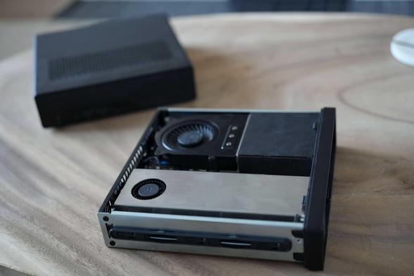 A mini computer with a discrete nvidia gpu installed sitting on a wooden coffee table