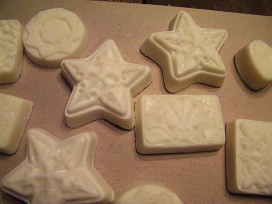 Fancy soaps with a slightly golden color in various shapes -- circles, stars, rectangles, hearts, squares -- with raised designs.