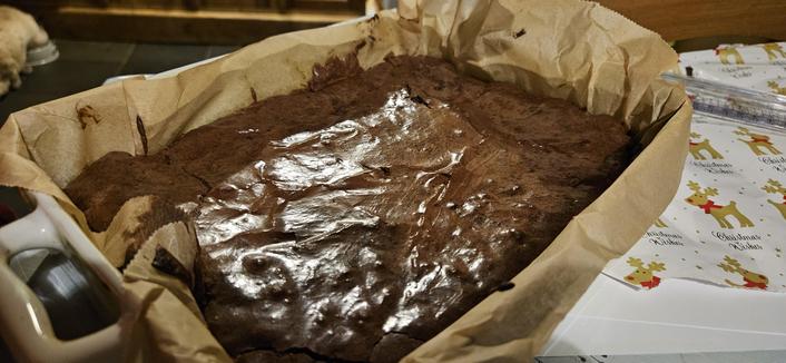 A trayful of chocolate brownie. It loss lumpy because there are larger chocolate chunks in there as well as the fully melted chocolate.