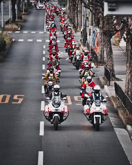 京都の大通りにたくさんのサンタクロースがはしっている　